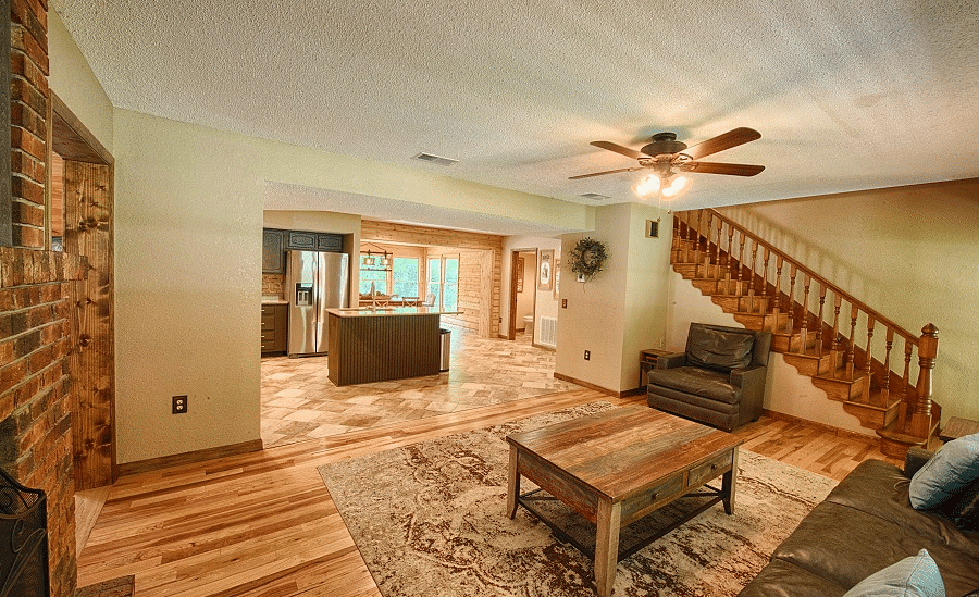 a living area with a brown sofa set along with a ceiling fan and a stairway leading to the upper level - Historic Tapoco Lodge