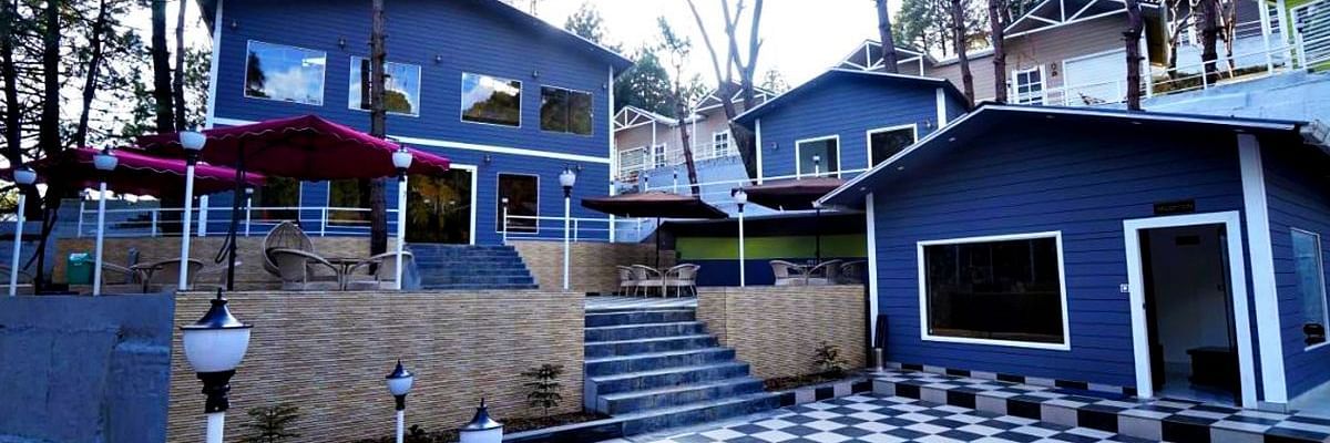 Facade of DLS Nature Trinket Resort with a blue building and a clear sky in the backdrop .