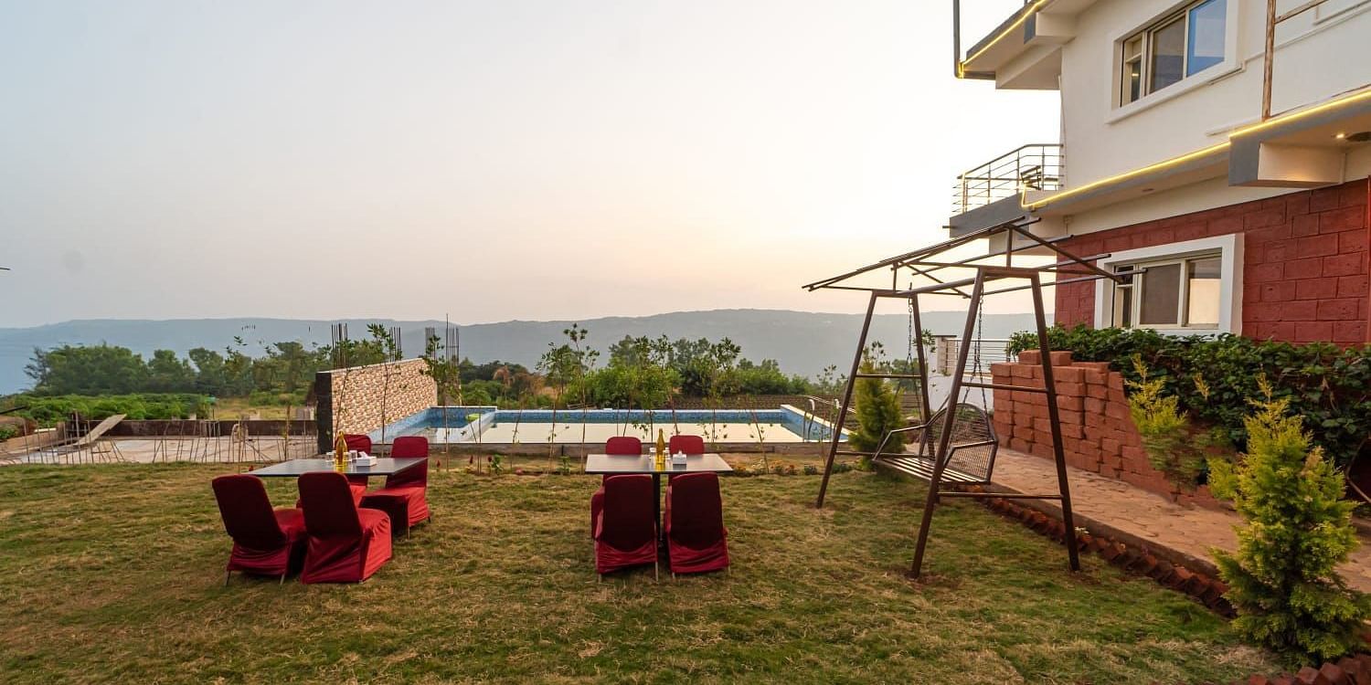 Outdoor lawn area next to a swimming pool featuring seating arrangements and a swing.