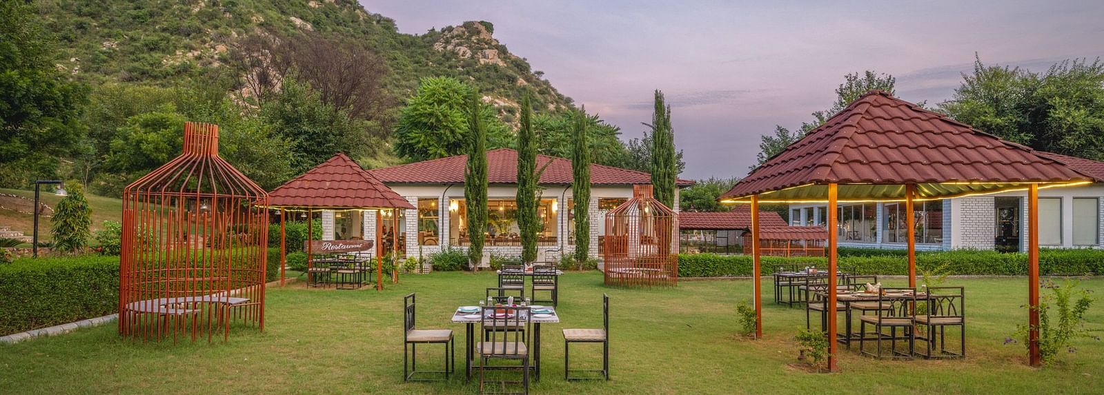 An open space at Valley by Grassfield, featuring tables and chairs, with mountains providing a stunning backdrop.