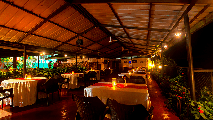 Image of a dining space with lights on the table at Coorg Jungle Camp Backwater Resort, Kushalnagar.