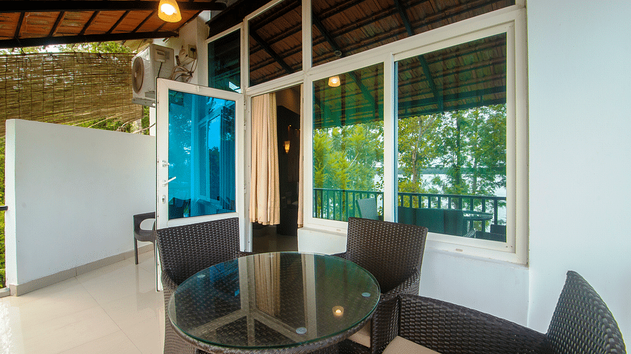 Image of a seating area with a table and chairs around it at Coorg Jungle Camp Backwater Resort, Kushalnagar.