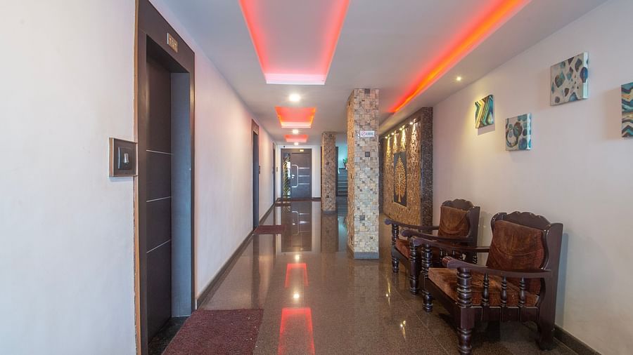 Image of a hallway with two chairs on the side with doors opposite to it at Parampara Residency, Kushalnagar.