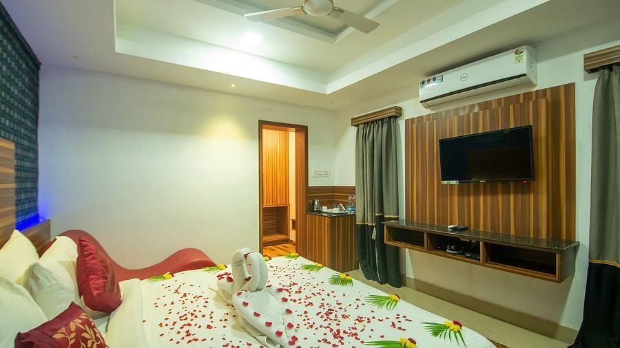 Image of a room with a bed decrated with flower petals and leaves at Parampara Resort & Spa, Kushalnagar.