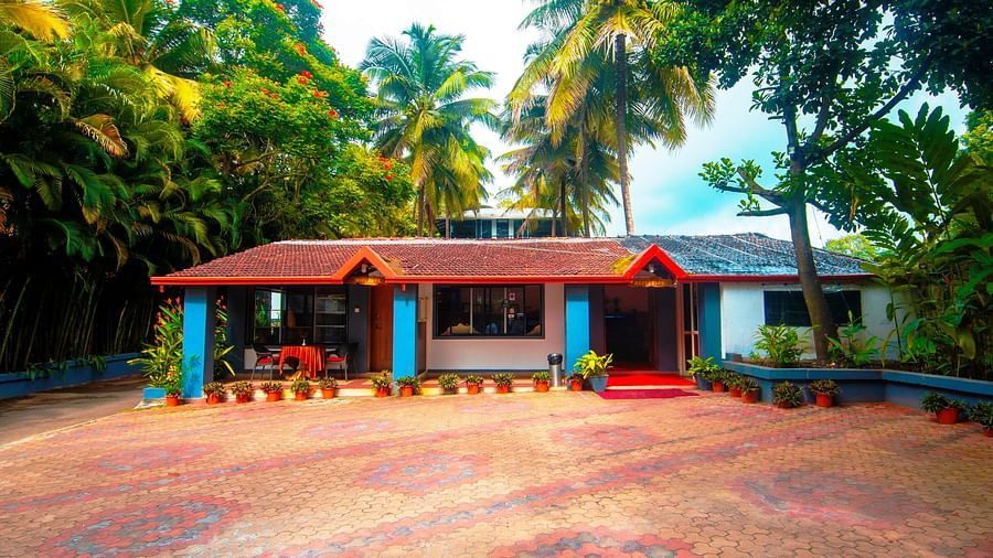 Facade of an accommodation with trees around it at Parampara Resort & Spa, Kushalnagar.
