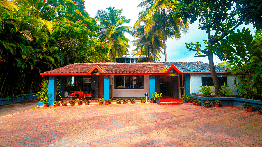 Facade of an accommodation with trees around it at Parampara Resort & Spa, Kushalnagar.