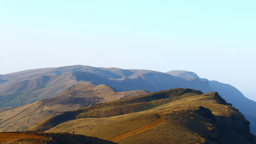a view from Mullayanagiri Peak of the rolling mountains with blue sky in the background