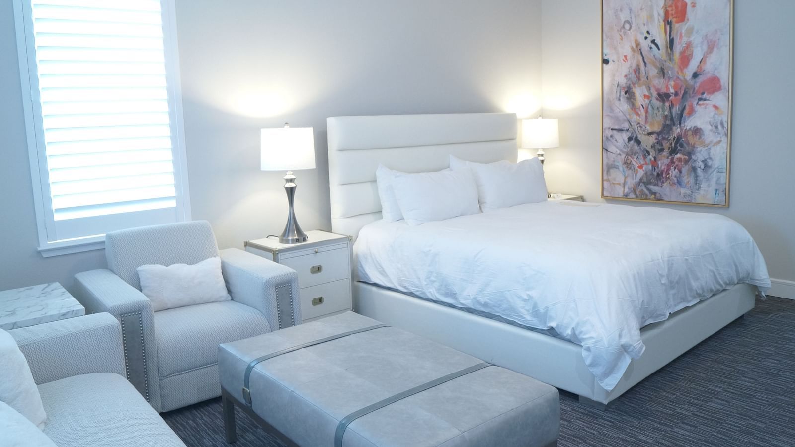 A stylish bedroom featuring a large bed, soft lighting, and minimalist furniture, designed for a comfortable stay - The Grand Hotel & Ballroom, McKinney