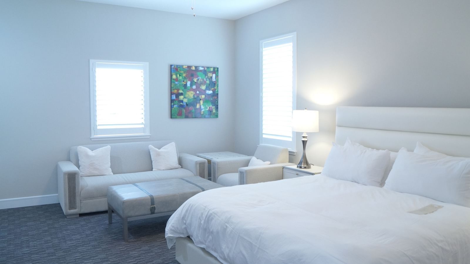 A stylish bedroom featuring a large bed, soft lighting, and minimalist furniture, designed for a comfortable stay - The Grand Hotel & Ballroom, McKinney