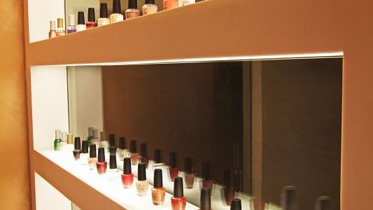 Image of various nail polishes kept on a shelf at IOSIS Spa & wellness Guwahati