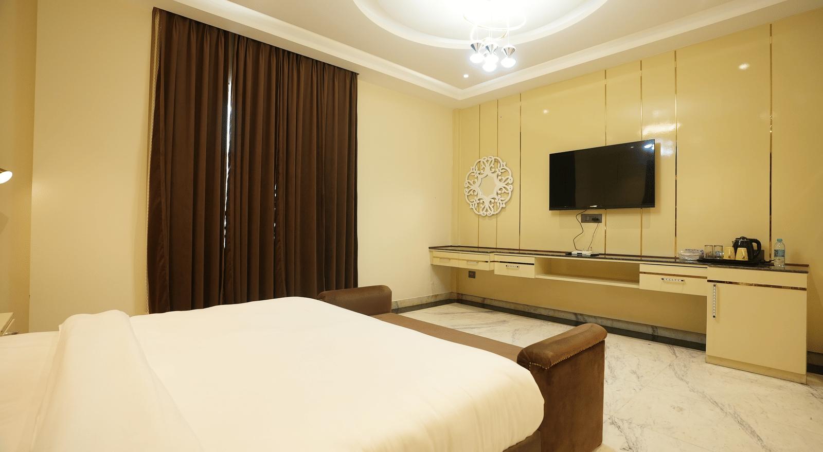 Cosy room with natural light and wall-mounted TV at Lime Tree Hotel Near India Expo Mart, Greater Noida.