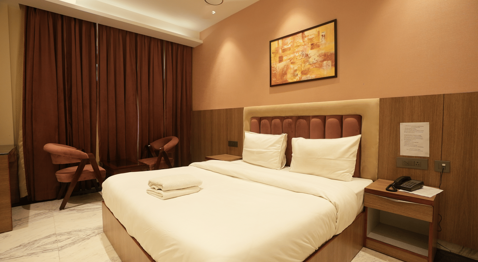 Warm-toned room with king size bed and curtains at Lime Tree Hotel Near India Expo Mart, Greater Noida.