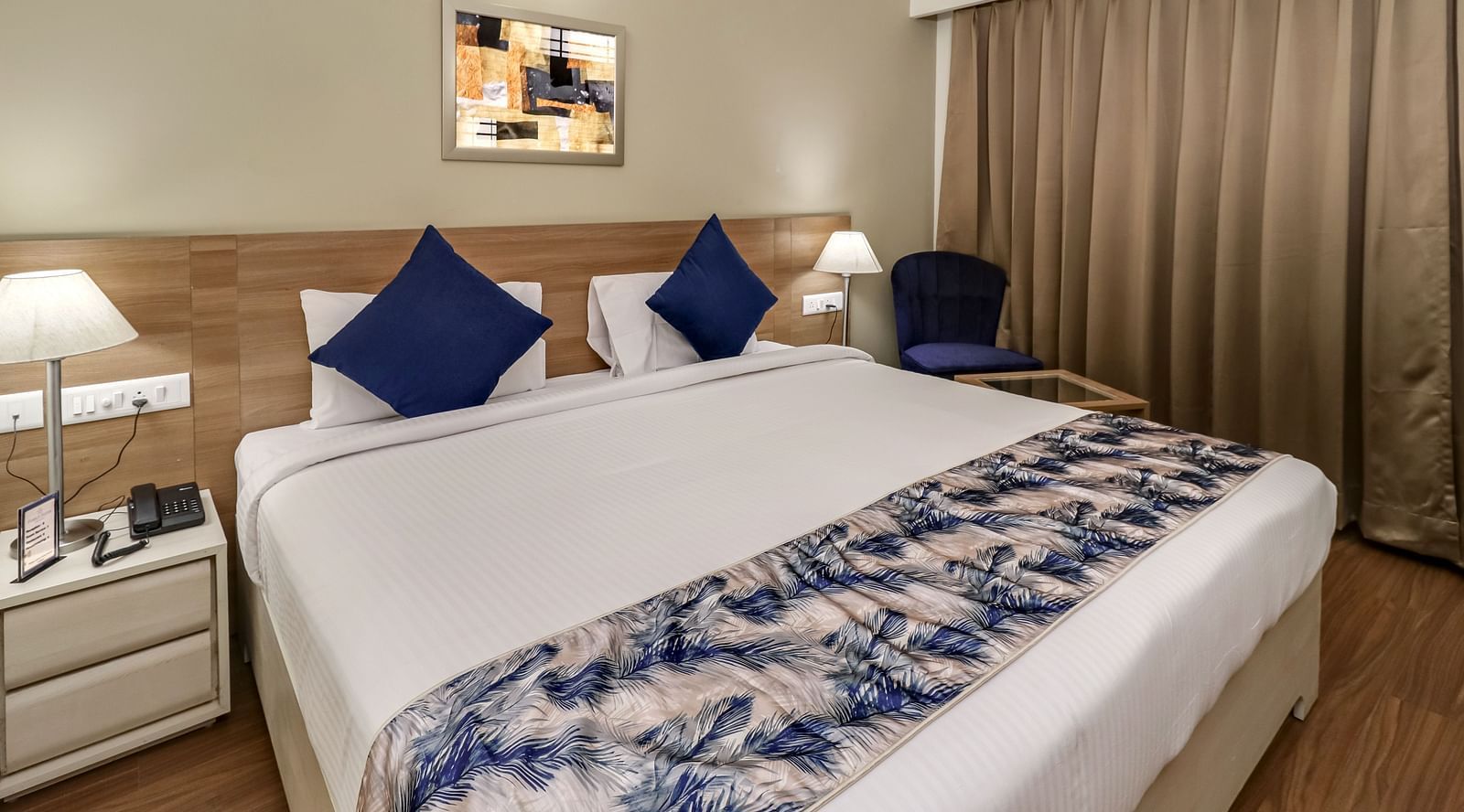 A double bed with side tables inside Deluxe Suite - Starlit Suites Newtown, Kolkata