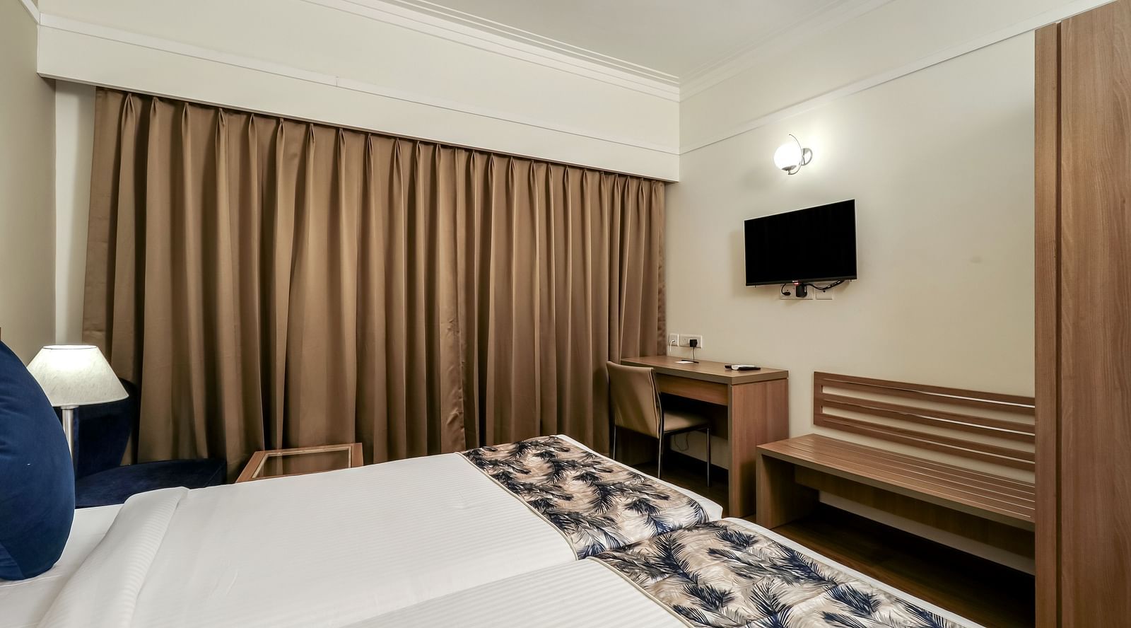 Twin bedw with a tv opposite it inside Premium Studio - Starlit Suites Newtown, Kolkata