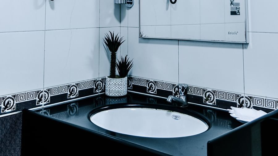 image of a wash basin along with a half mirror in the grand suite bathroom - The Grand Krishna Rooms, Bengaluru