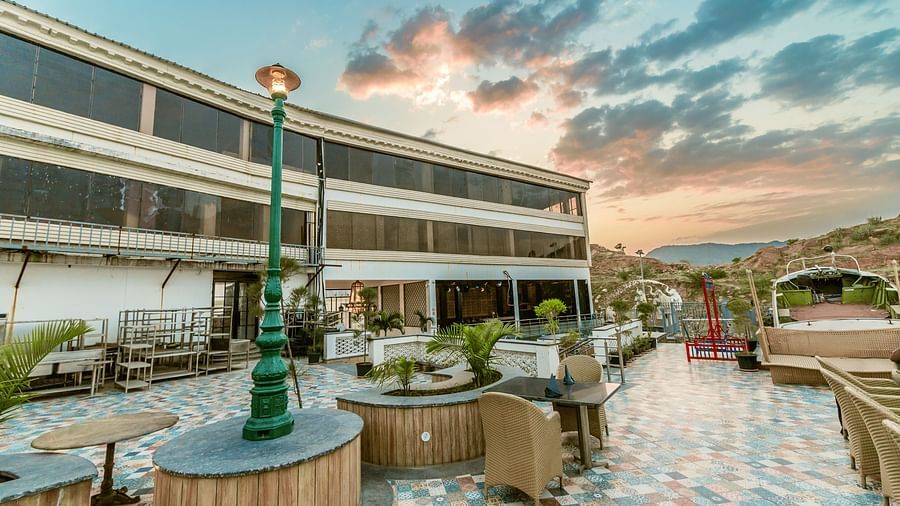 An image of an open air dining area in front of an old building