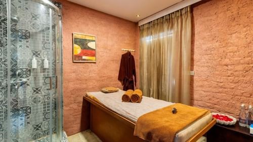 Spa room with two beds and curtain-draped window at Golden Tulip, Udaipur.