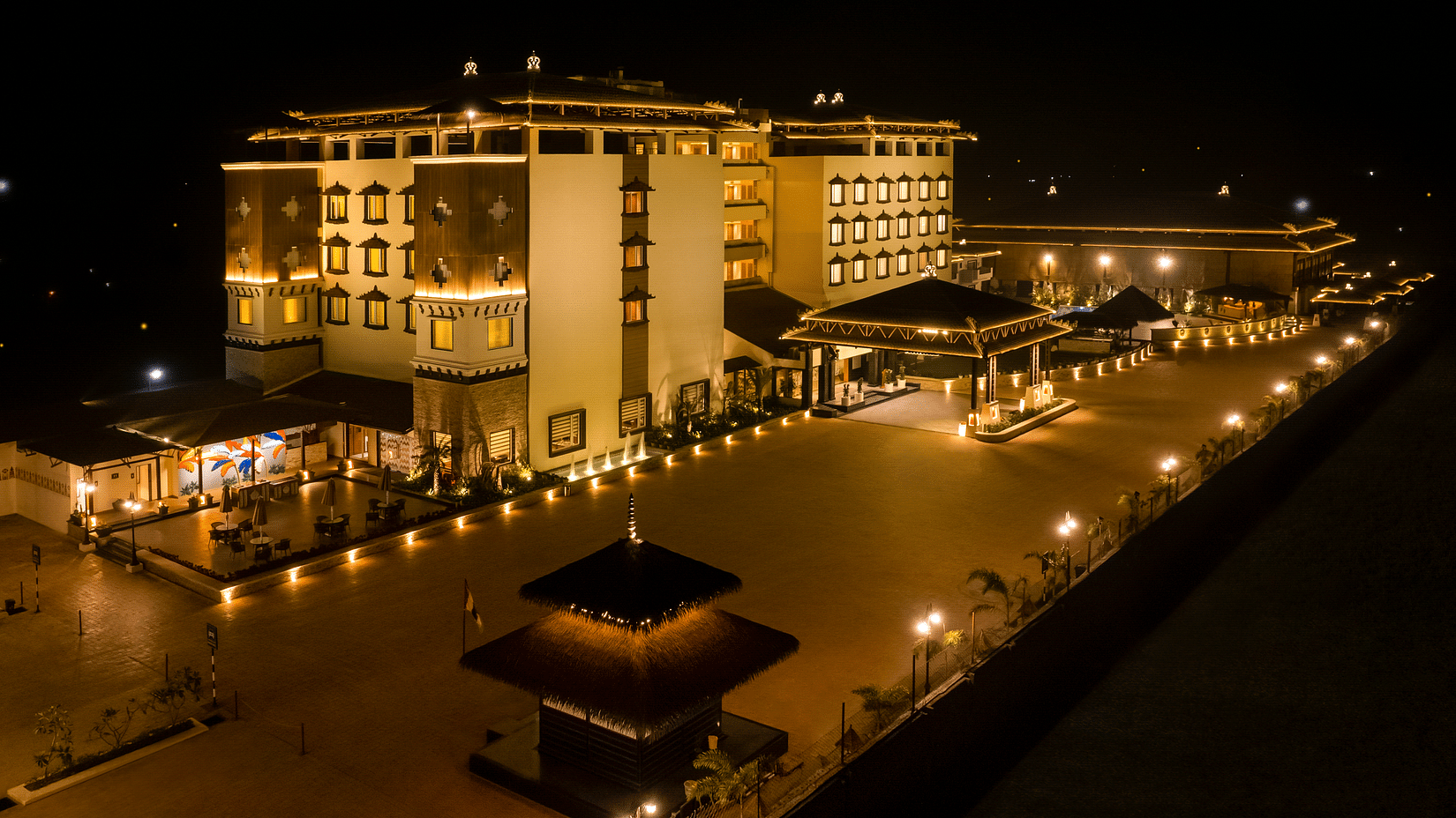 An aerial view of the facade at night - Shyama Sarovar Portico Orai