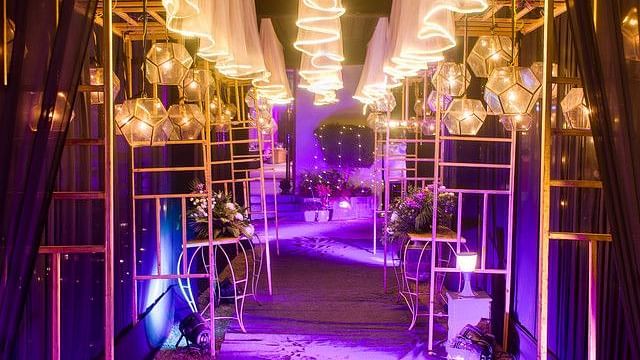 alt-text Illuminated stage with lighting and floral arrangements.