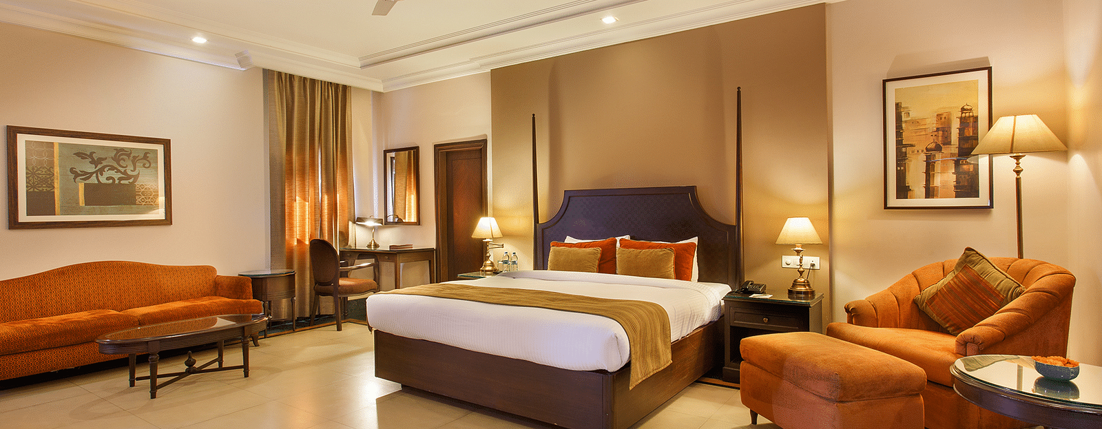 Maharaja Suite with two sofas and a large bed in the middle with standing lamps - Ganga Lahari, Haridwar
