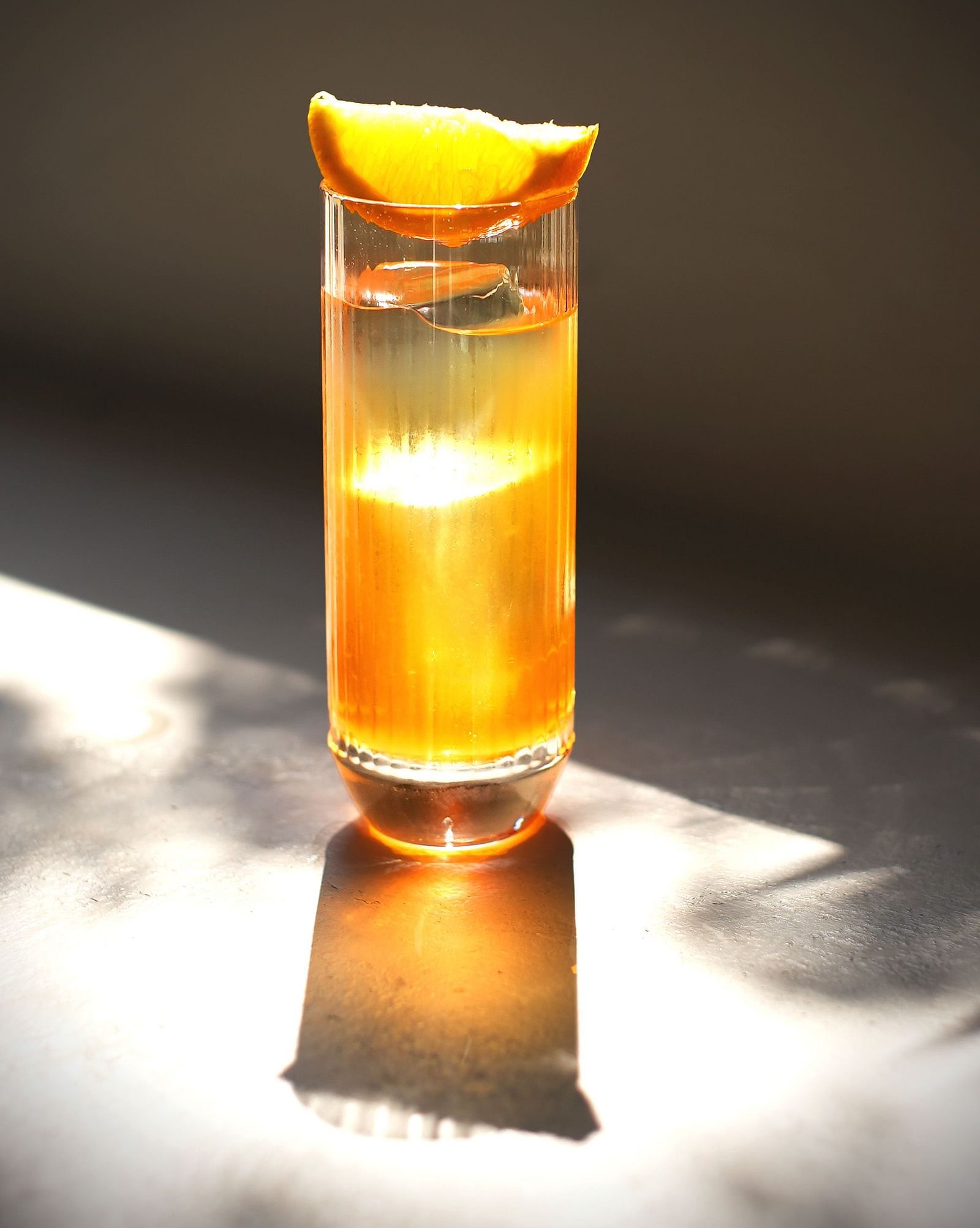 Thai chai drink in a glass with sun shining on it
