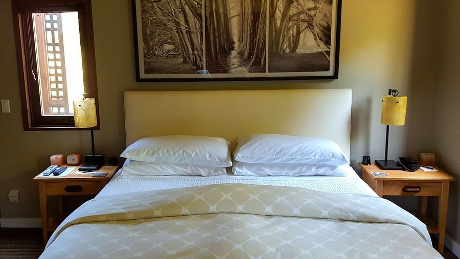 A charming bedroom featuring a large bed, wall-mounted paintings, soft lighting and elegant decor - Brewery Gulch Inn & Spa