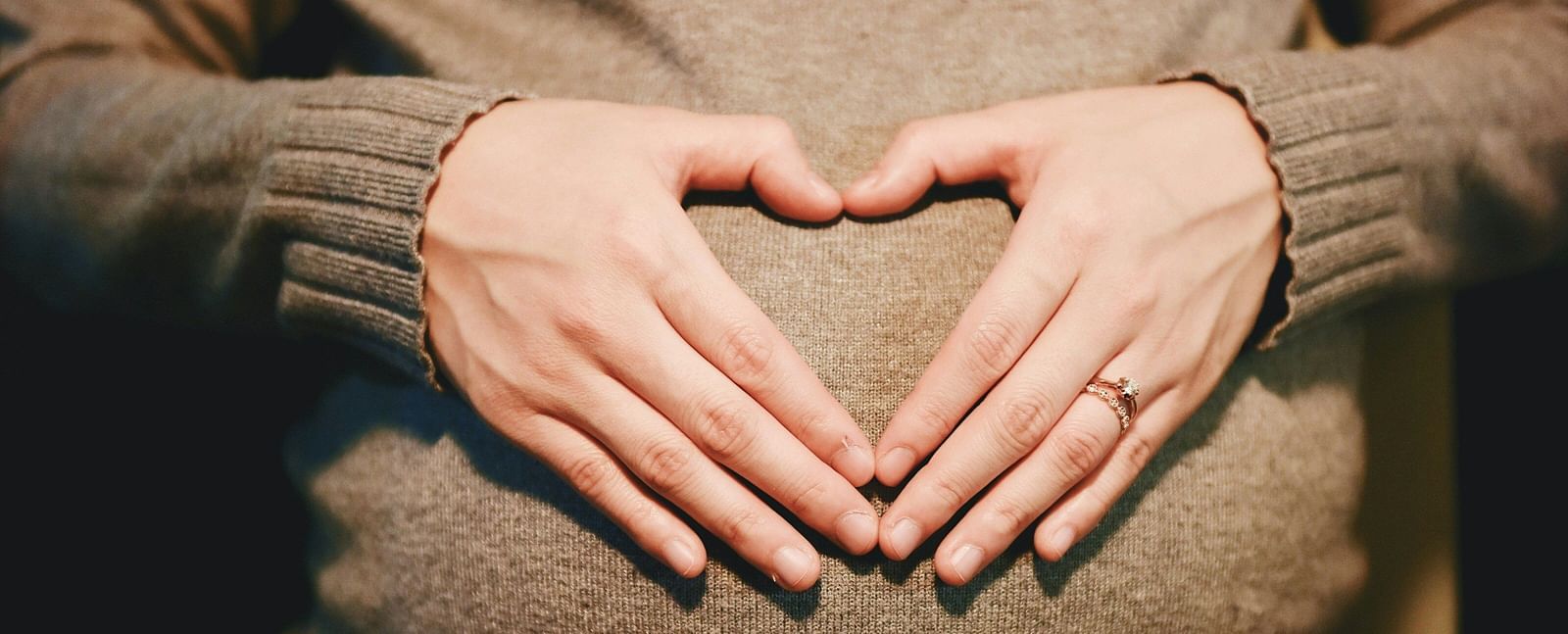 Loving hands gently cradling a growing baby bump