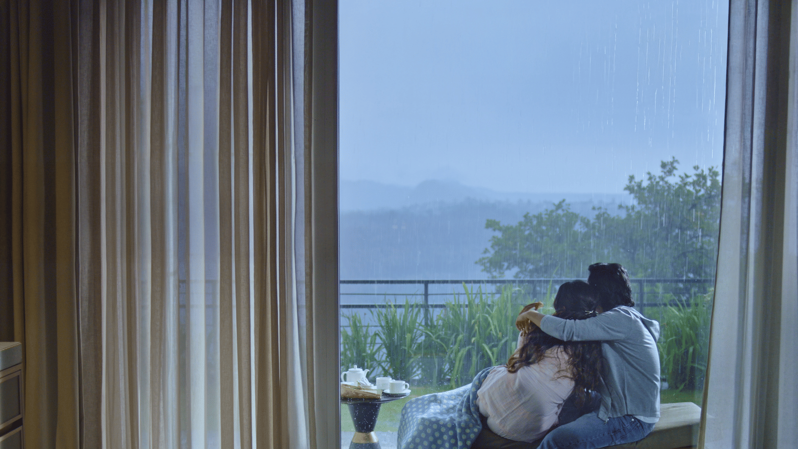 A couple sitting on the porch as they overlook the beautiful views from our wellness and spa resort in Khandala.