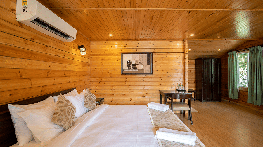 Premium Cottage in Goa features wooden interiors and a plush bed - Stone Wood Riverfront Resort, Siolim