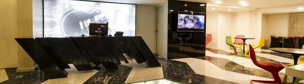 Reception area witha counter table and televion on the wall at Art Boutique Hotel, Hyderabad 