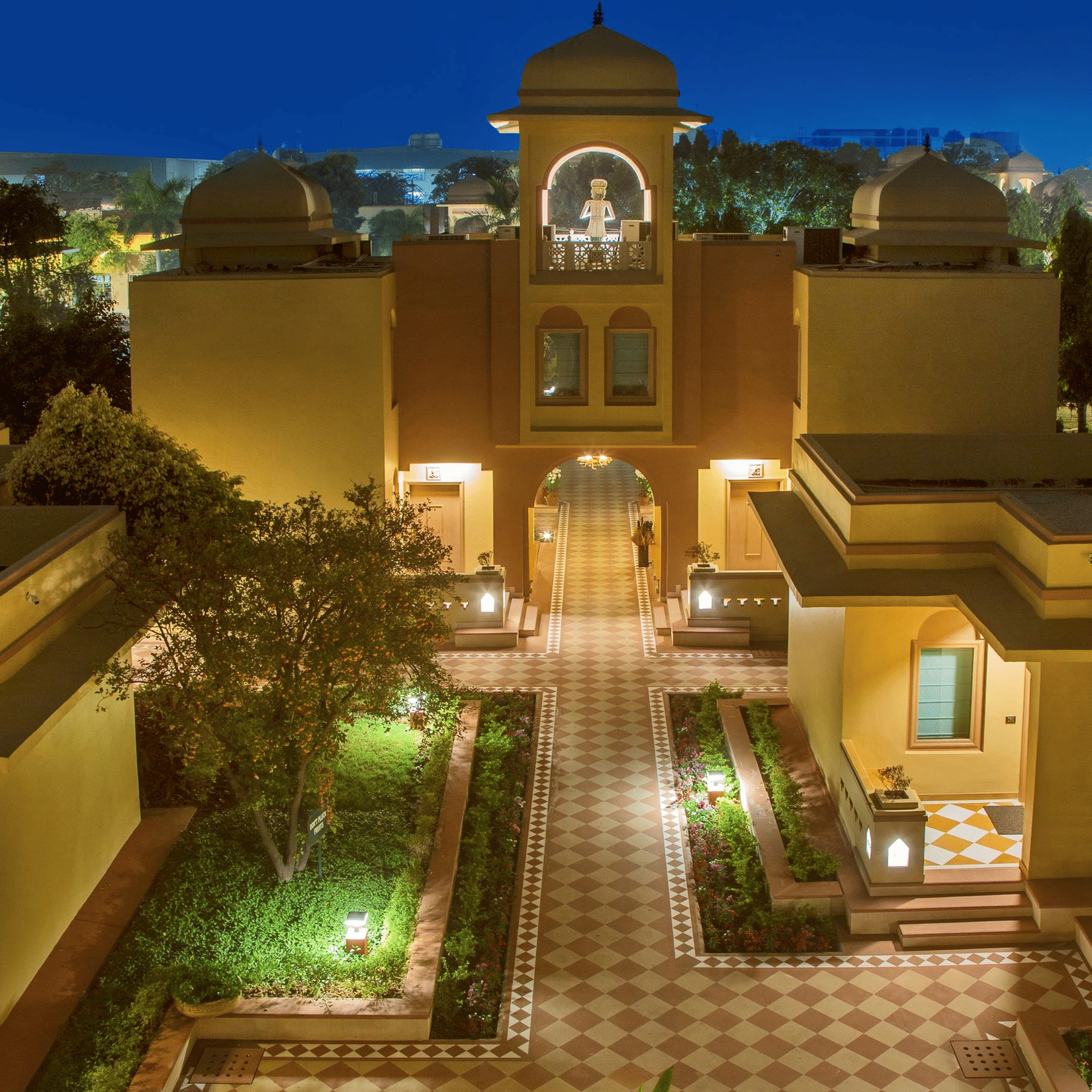 A beautifully illuminated courtyard of Heritage Village Resort & Spa, Manesar, one of the luxury resorts in Gurgaon, with elegant Rajasthani-inspired architecture and landscaped surroundings.