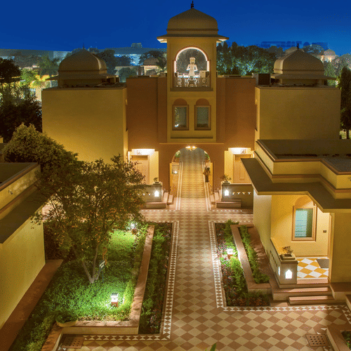 A beautifully illuminated courtyard of Heritage Village Resort & Spa, Manesar, one of the luxury resorts in Gurgaon, with elegant Rajasthani-inspired architecture and landscaped surroundings.