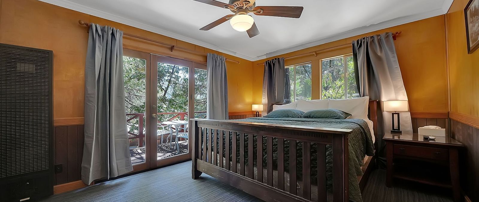 A view of a room at Narrow Gauge Inn with a double bed and French windows.