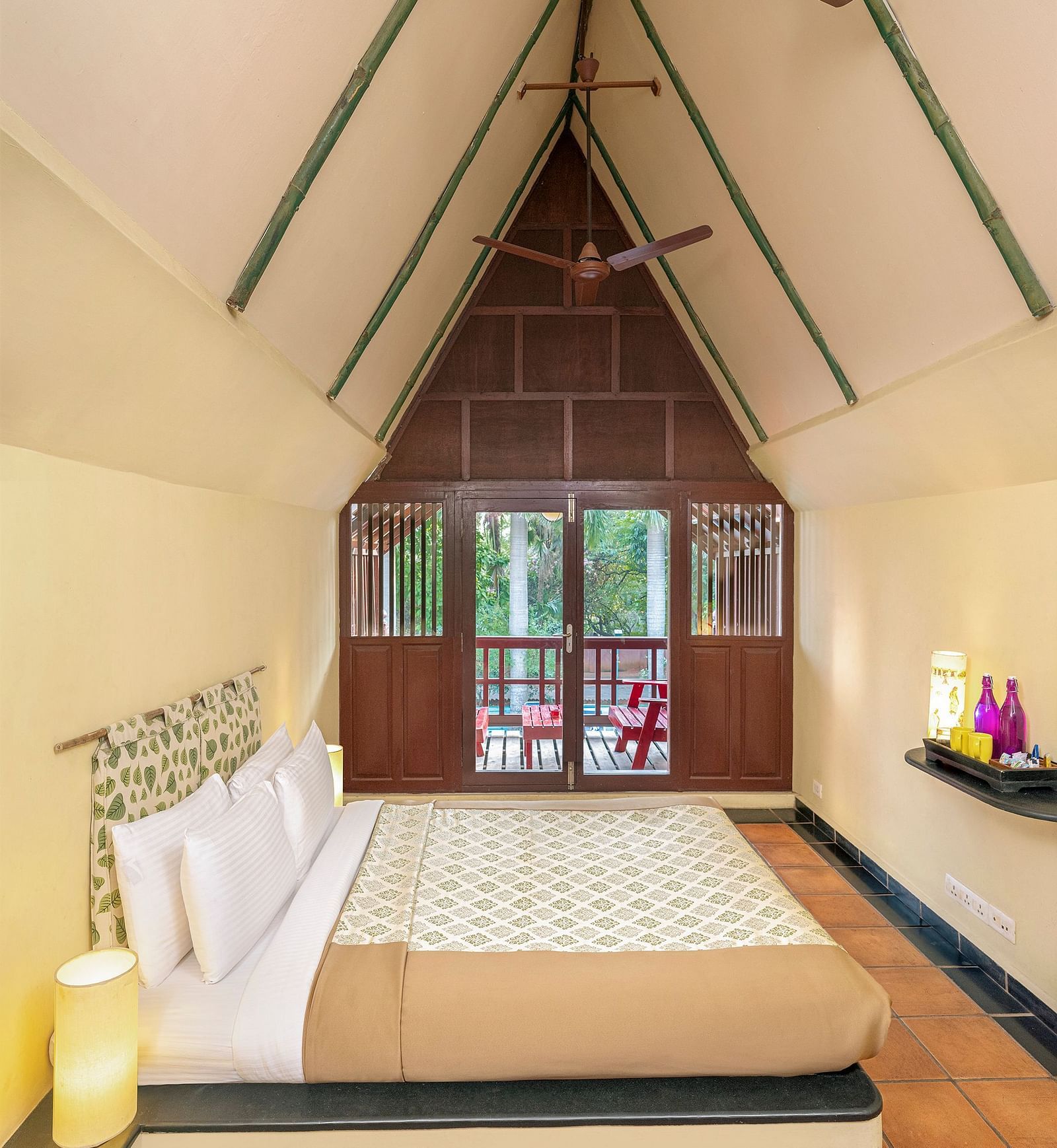 A double bed with side tables and lamps inside Thai Cottage in Mango Hill, Pondicherry