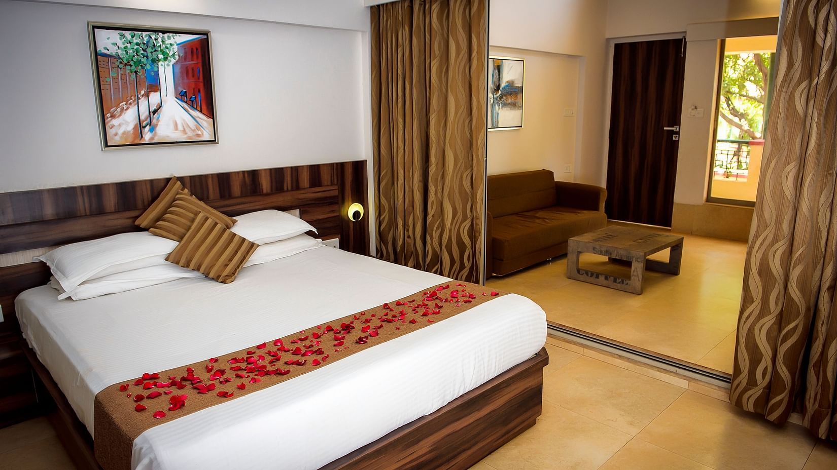 Deluxe villa bedroom interior featuring a bed, sofa and coffee table - Adamo Resort Matheran