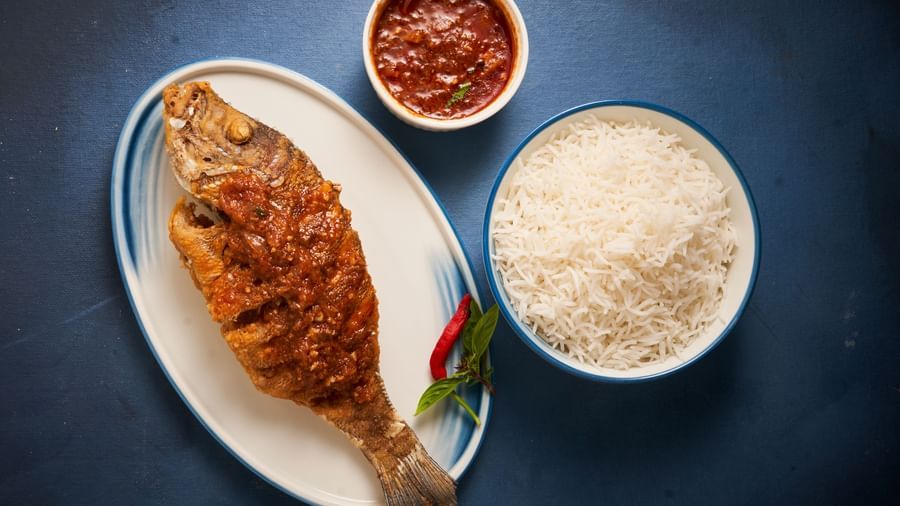 A whole fried fish on a plate served with white rice and chutney at Grande Bay Resort & Spa.
