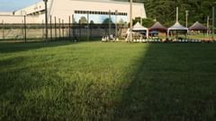 Lawn area with seating tents and a building in the background at Golden Tulip, Udaipur.