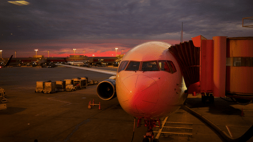 A close-up shot of an aircraft during a late evening with the aerobridge attached.