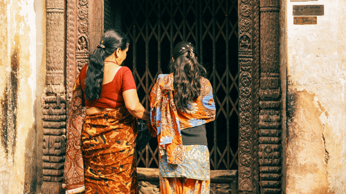 a over the shoulder shot of two women entering the temple