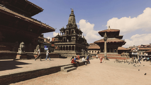A bustling public square with traditional Nepalese architecture, including a tiered pagoda temple.