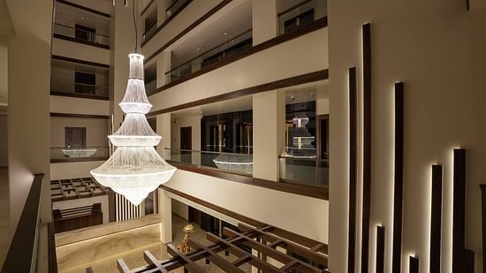 View of the lobby with contemporary design and chandelier light - Mastiff Grand - The Sia Palace Suites Banquets Khopoli