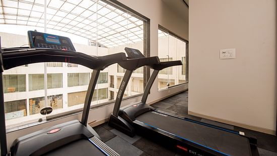 two treadmills kept side by size in a gym shot during the day - Mastiff Hotel, Ankleshwar