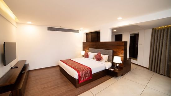  A view of the bedroom with a telivsion, ambient lights and a seprate living area | The Terrace Business Hotel
