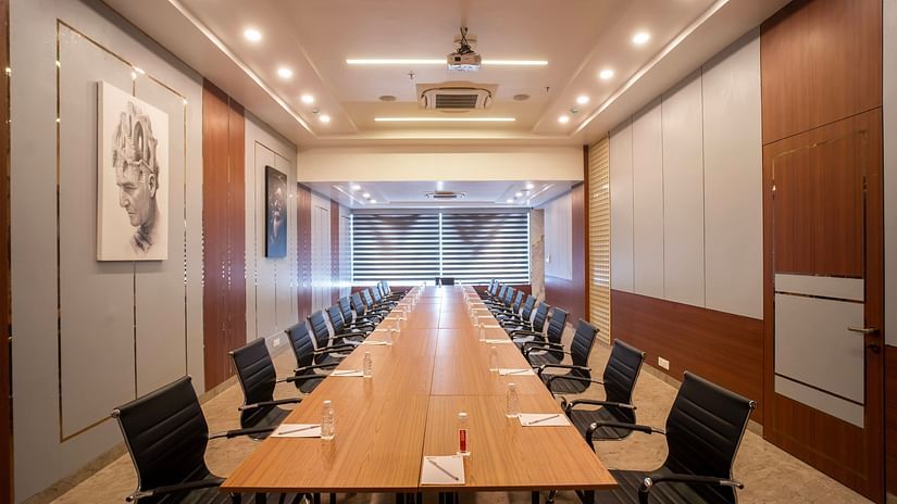 A long view of the boardroom with chairs and table with dim lights at Mastiff Select Medha Plaza, Deoghar
