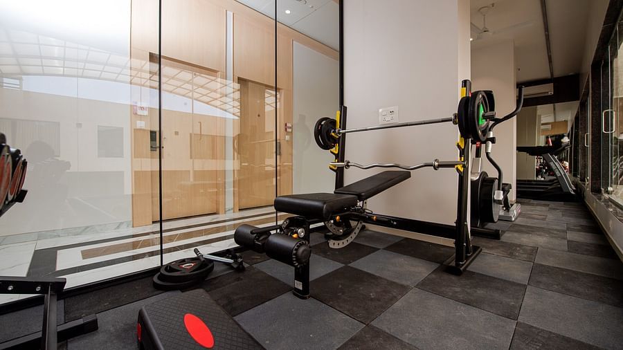 a gym area with fitness equipment - Mastiff Hotel, Ankleshwar