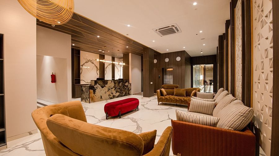lobby area with a pair of white couch for customers to wait or relax - Mastiff Hotel, Ankleshwar