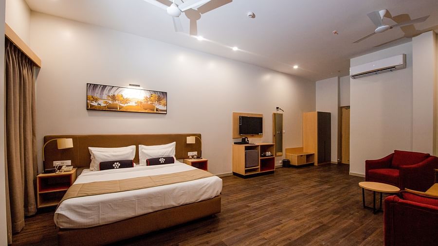 a grand suite room with plush interior designed with soft hues of white - Mastiff Hotel, Ankleshwar
