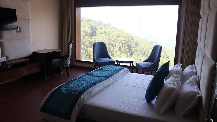Side top view of seating area with coffee table along with scenic view from the window - Mastiff Hotel, Dalhousie