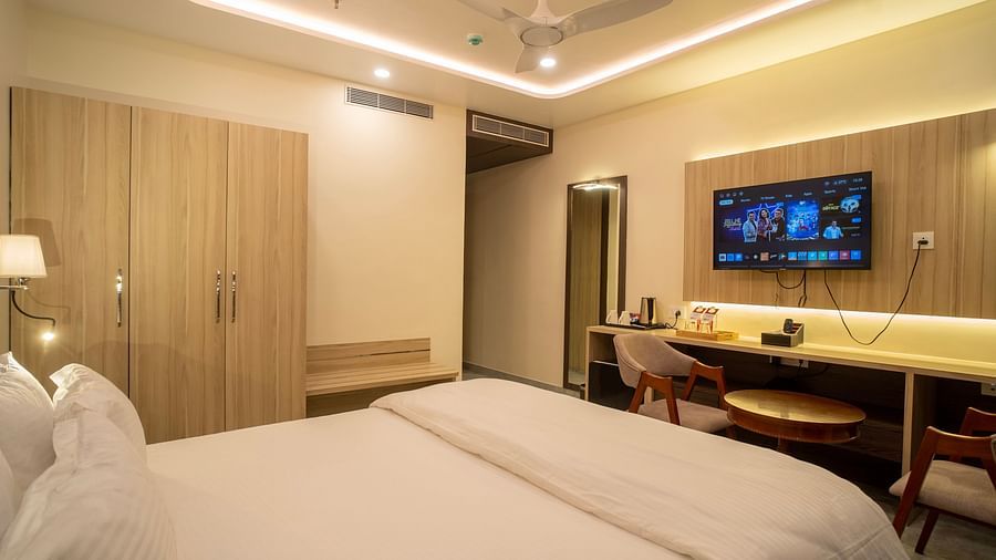 A corner view of the room with plushy bed, Tv, table and a chair at Mastiff Select Medha Plaza, Deoghar