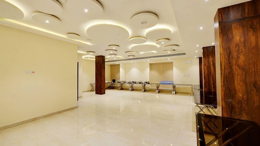Empty banquet hall with stylish ceiling lights and large reflective windows.